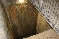 The deep shaft, lined with iron rungs