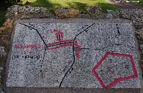 A tablet shows the layout of the village before the war