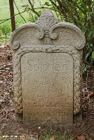 The original grave marker can still be seen close by